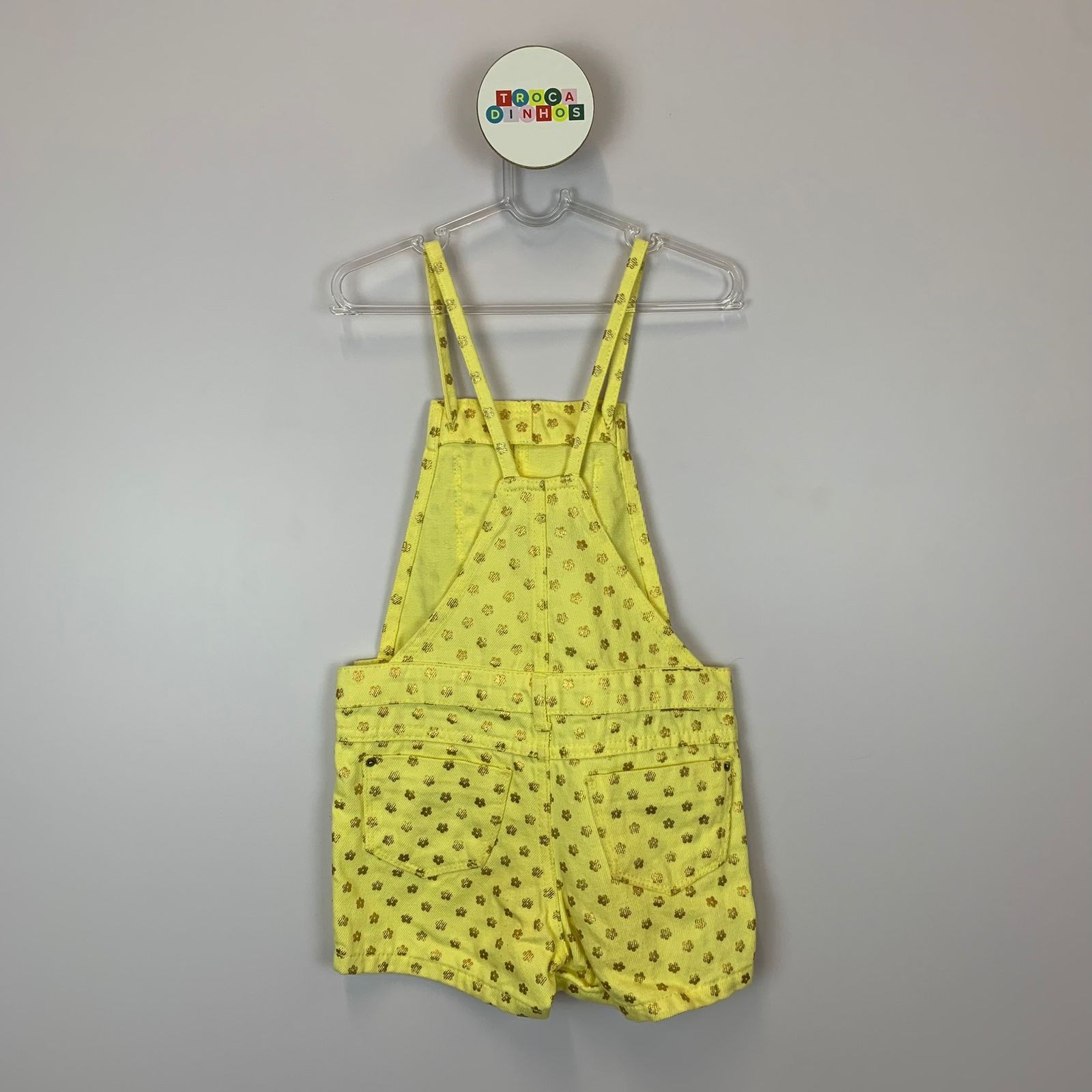 Jardineira amarelo e flores douradas.